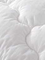 Gros plan sur l’enveloppe 100 % coton 233 fils de la couette duvet et plumes Sleepillo