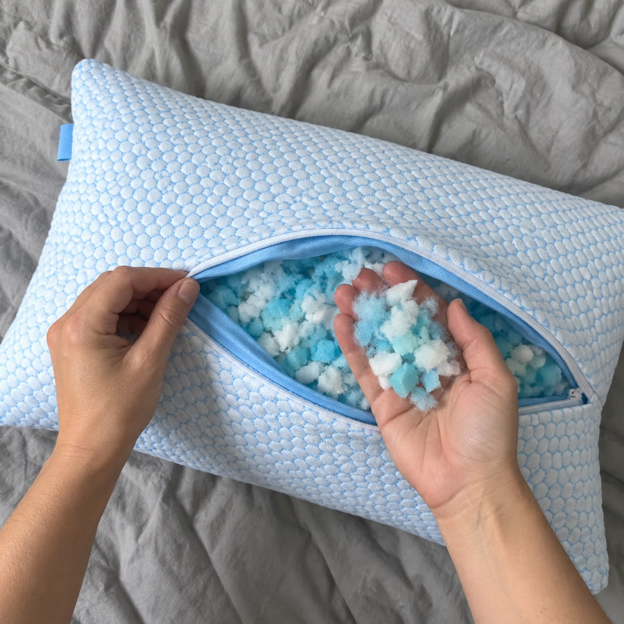 Réglage de l’oreiller Sleepillo : main qui retire de la mousse vue du dessus