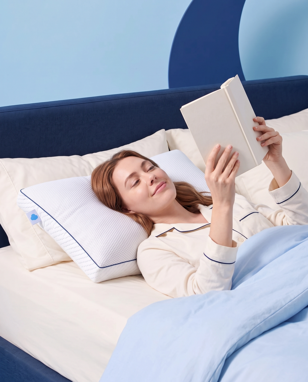 Femme lisant au lit, la tête posée sur l’oreiller Sleepillo Recharge